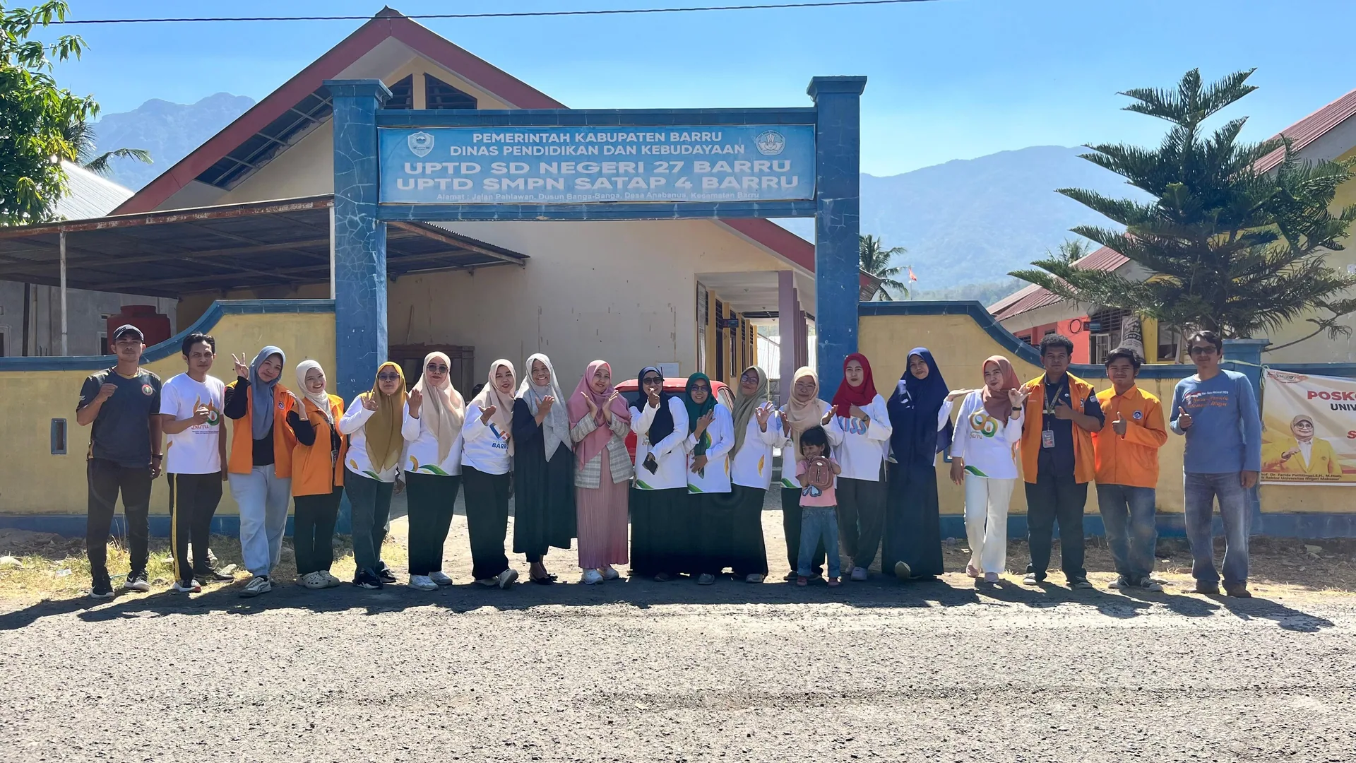 Warga sekolah berfoto di depan gedung sekolah.